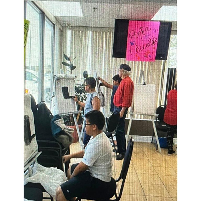 Participants working on paintings during a community art class