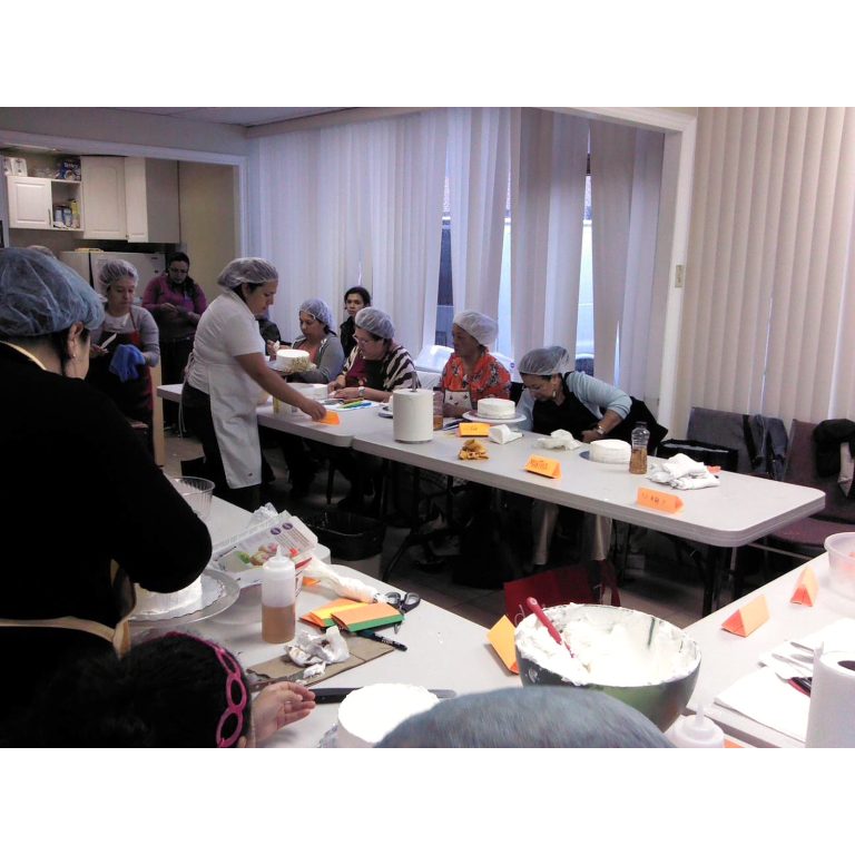 Participants learning cake decorating in a practical baking class