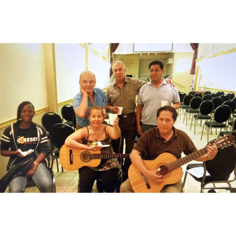 Community members participating in a guitar learning activity