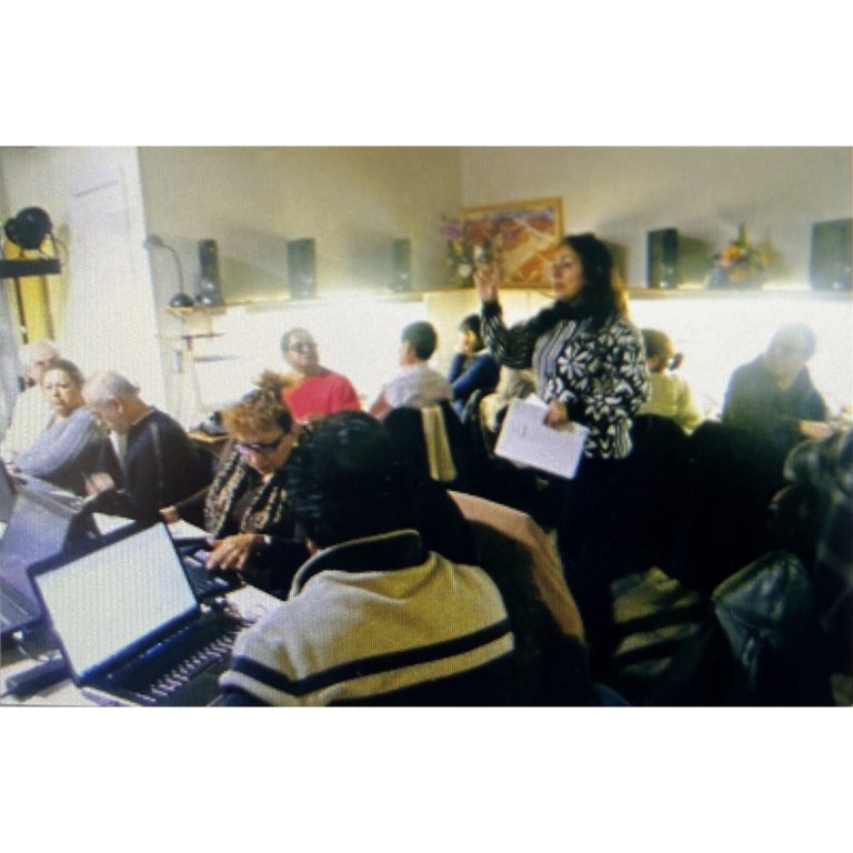 An instructor supporting adults during a computer class