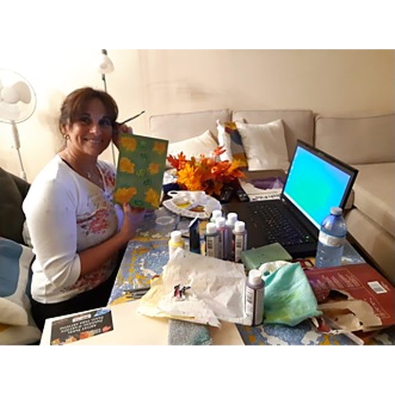 A participant displaying a completed autumn craft project